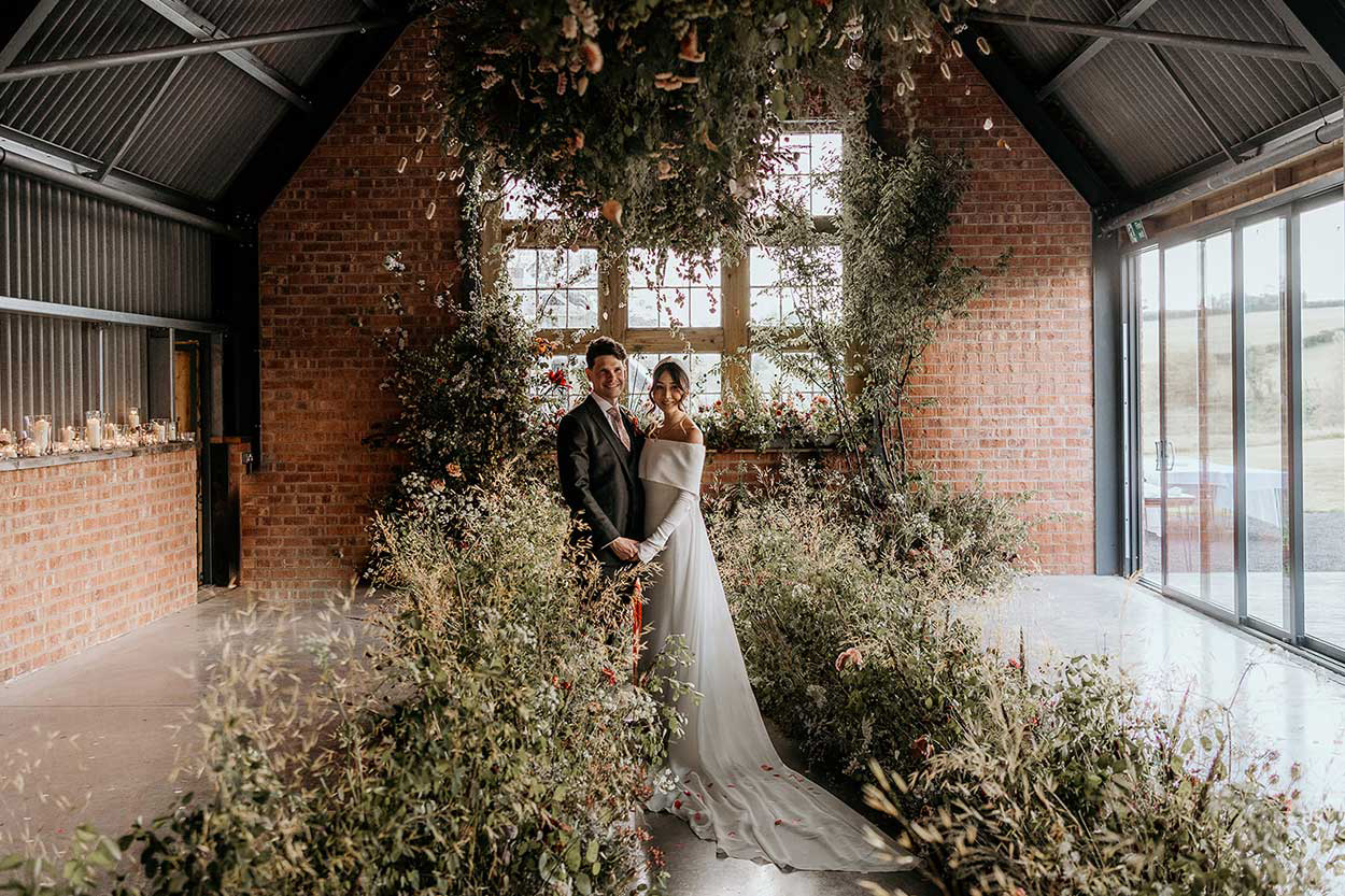 wedding portrait inside amongst plants against brick