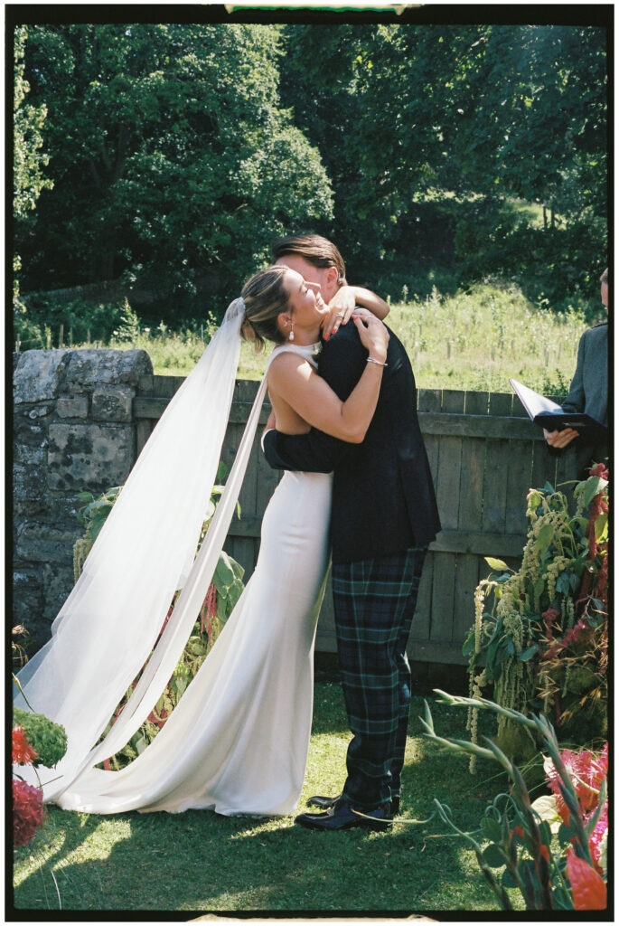 Bride and groom sharing quiet moment in flower meadow, St Andrews Scotland film photography