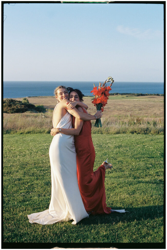 Bride and bridesmaids in colourful dresses posing with parasols at Kinkell Byre wedding shot on film