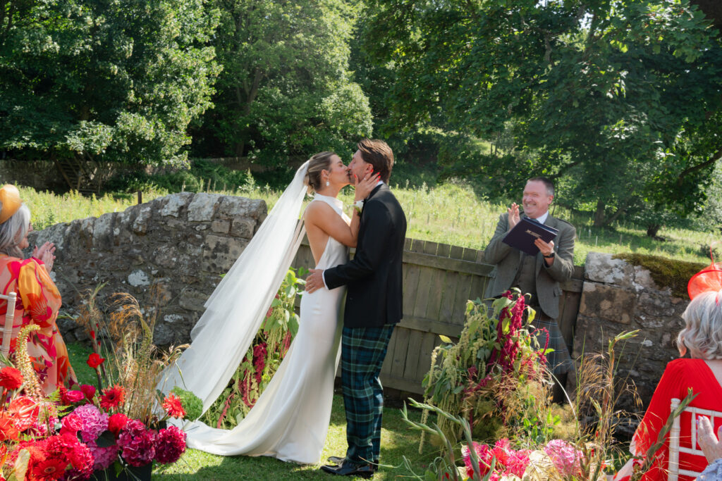 Bride and groom sharing quiet moment in flower meadow, St Andrews Scotland film photography