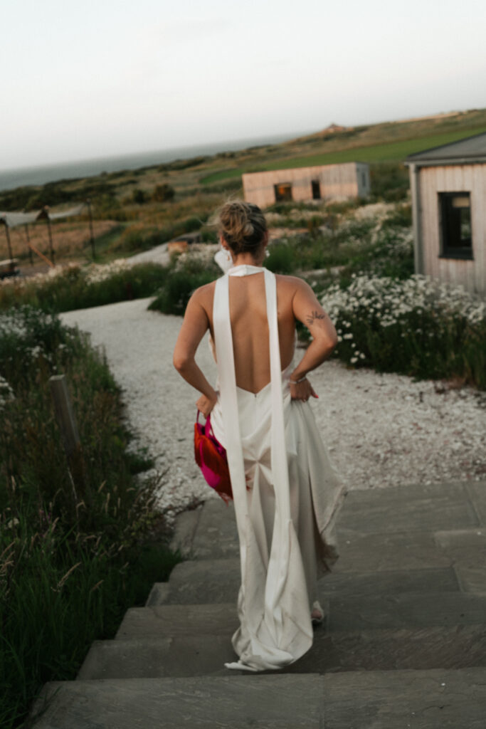 Bride and groom leaning on white classic car with sea view, film wedding photographer Scotland