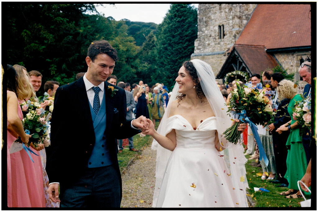 Bride & Groom coming out of a church in Wales shot on 35mm film photography